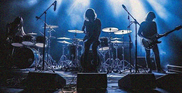 Band performing on stage with blue lighting